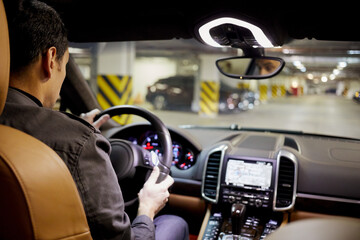 Wall Mural - Man drives car at underground parking, focus on his head.