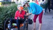 © Robert Peak - Senior and mature woman take a break while biking to look at a map on their phone for directions.