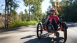© Robert Peak - Low angle closeup of elderly senior woman riding recumbent tricycle e-bike on a path on a sunny day in a park.