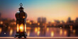 Ramadan Kareem greeting card with glowing lantern and blurred bokeh lights background in orange and blue.