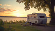 A camper parked next to a serene lake at sunset. Perfect for travel and outdoor adventure concepts