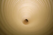 Direct view into a beige paper plastic tunnel creating a hypnotic concentric pattern.