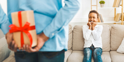 Wall Mural - Father making surprise to little daughter, hiding present