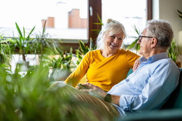 Sticker - Portrait of a happy senior couple sitting on sofa at home
