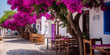 vibrant pink flowers hanging over quaint street with outdoor seating