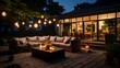 View over cozy outdoor terrace with outdoor string lights. Summer evening on the patio of beautiful suburban house with lights in the garden.
