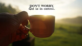 Fototapeta  - Morning inspirational quote - Don't worry. God is in control. With person holding a cup of coffee or tea against the warm sunrise light background. Faith and hope. Believe in God concept.