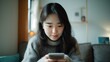 © Pro Hi-Res - Asian woman uses mobile phone texting in social networks. Online communication, mobile technology and social media.