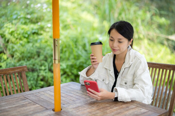 Sticker - Woman drink of coffee and use smart phone at outdoor coffee shop