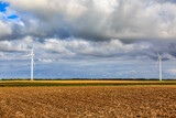 Fototapeta  - Plain field in autumn with wind turbines