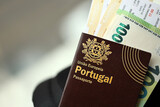 Fototapeta  - Red Portugal passport of European Union with money and airline tickets on touristic backpack close up. Tourism and travel concept
