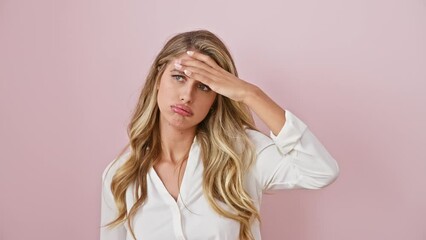 Sticker - Troubled blonde woman in shirt stressfully broods over crisis, her hand on forehead, embodying worry against isolated pink backdrop