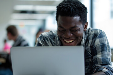 Wall Mural - young black man using a laptop at an office