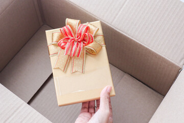 Young woman unboxing gift box in cardboard box,black friday concept.