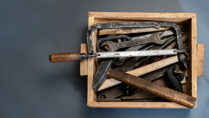 An old carpentry tool in a wooden box on a gray background