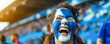 Happy Scottish female supporter with face painted in scotland flag which consists of a white saltire defacing a blue field, Scottish female fan at a sports event such as football or rugby match
