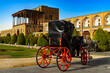 Iran. Isfahan. Naqsh-e Jahan Square (UNESCO World Heritage Site). One of the numerous buggies running around the square and Ali Qapu Palace in the background