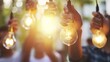 Multiple hands hold glowing light bulbs against a backdrop of natural sunlight, symbolizing innovation, teamwork, and a collective drive towards bright ideas
