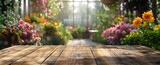 Fototapeta Tulipany - Wooden Table in Greenhouse Filled With Flowers