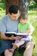 © Kostia - happy father with a child reading a book on the nature of the Bible
