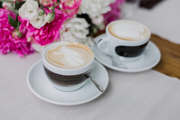 Two cups of cappuccino with elegant latte art, perfect for social meet-ups and coffee breaks