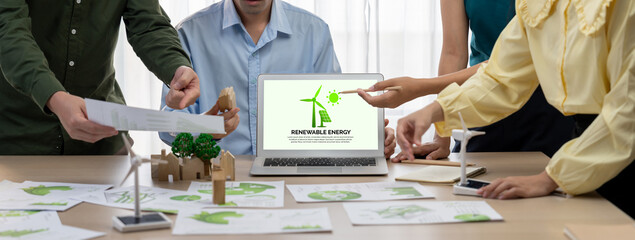 Wall Mural - Renewable energy logo displayed on green business laptop while business team represented green design to customer. ESG environment social governance and Eco conservative concept. Closeup. Delineation.