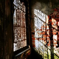 Sticker - a brick wall with a shadow of a window and a brick wall with a shadow of a window on it.