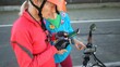 © Robert Peak - Senior and mature woman take a break while biking to look at a map on their phone for directions. Making a call.