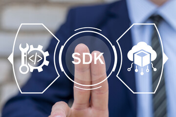 Wall Mural - business man using virtual touchscreen presses abbreviation: sdk. concept of sdk software developmen