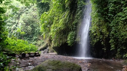 Wall Mural - Tripod footaget of small waterfall nearby Tukad Cepung waterfall. Bali, Indonesia.