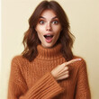 young woman with brown hair wearing a brown turtleneck sweater appears pleasantly surprised