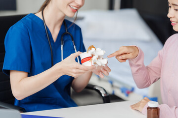 Caucasian female doctor explain to asian female patient using Human Anatomical Lumbar Disc Herniation Model at desk in medical room, medical learn aid anatomy instrume