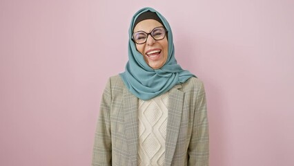 Poster - Fun loving middle-aged hispanic woman in hijab sticking tongue out in joyous expression over pink isolated wall, mad happiness bursting out!