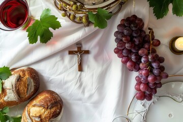 Eucharistic elements such as wine, bread and bunch of grapes on a table with a white tablecloth with a Catholic cross and a lit candle. Elevated view.