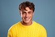 A man in a yellow sweater smiling at the camera. Suitable for various concepts