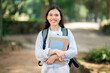 © Prostock-studio - Cheerful college student with a radiant smile carrying textbooks and a backpack