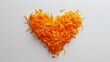 Closeup of heart shaped grated orange carrots, valentine heart of carrots. Isolated on white background