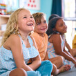 © Monkey Business - Line Of Smiling Primary Or Elementary School Students Sitting On Floor During Classroom Lesson