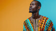 Confident African man in traditional African dashiki shirt on yellow background. Studio portrait emphasizing cultural fashion and identity concept for design and editorial.