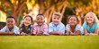 © Monkey Business - Portrait Of Multi-Cultural Primary Or Elementary School Student Friends Lying On Grass Outdoors