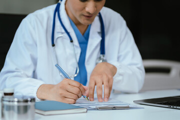 Wall Mural - Doctor working on laptop computer and tablet and medical stethoscope on clipboard on desk, electronics medical record system EMRs concept.