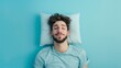 a young man sleeping on pillow isolated on pastel blue colored background Sleep deeply peacefully rest. Top above high angle view photo portrait of satisfied .senior wear blue  shirt