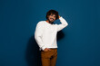 © deagreez - Photo of young positive wavy hairstyle funny guy in white pullover candid looking at cameraman isolated on dark blue color background