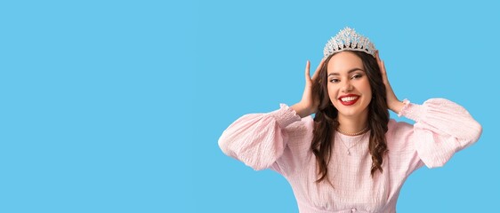 Wall Mural - Beautiful happy young girl in stylish prom dress and tiara on light blue background with space for text