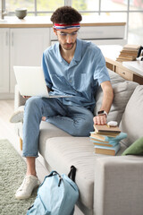 Canvas Print - Male student studying with laptop at home