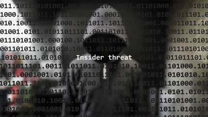 cyber attack insider threat text in foreground screen, anonymous hacker hidden with hoodie in the bl