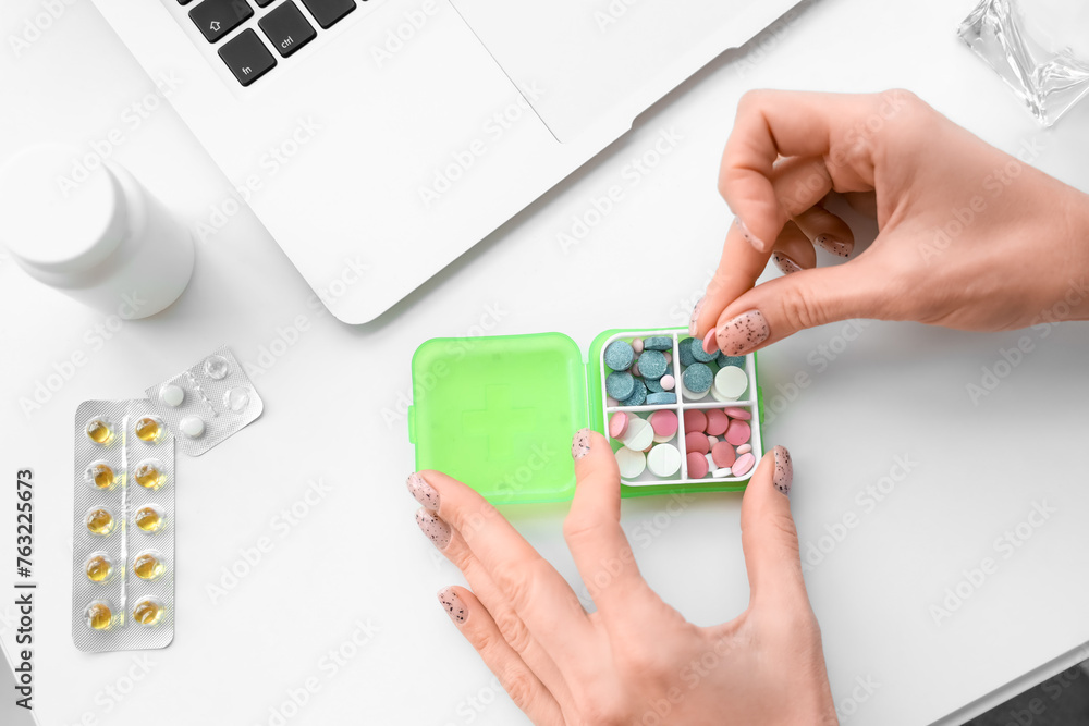 Mature woman selecting pills from pillbox at home, closeup
