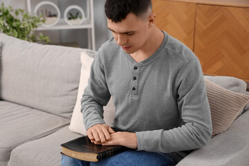 Sticker - Young man with Bible praying in living room