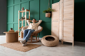 Wall Mural - Young man resting in armchair at home