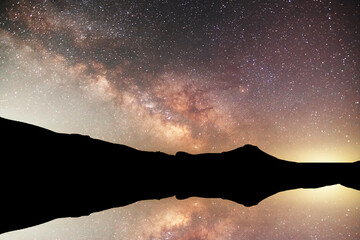 Wall Mural - night landscape, bright milky way galaxy with reflections in the water.